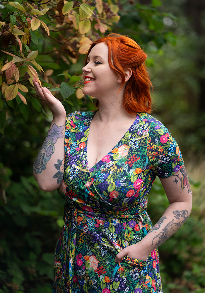 Woman in a colorful floral dress standing in a natural setting