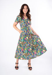 Woman wearing a colourful floral midi dress with hand in pocket