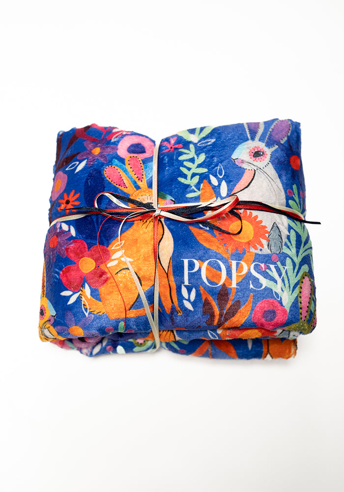 Front view of Garden Bunnies Blue Print Pop-under Plush Blanket