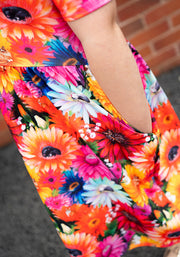 Colorful floral dress with a brick wall background