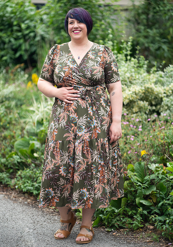 Woman wearing a floral tiger midaxi dress standing in a garden
