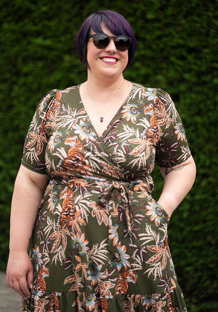 Woman wearing a floral midaxi dress with a green floral and tiger background