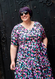 woman wearing a colourful dress with hand in pocket
