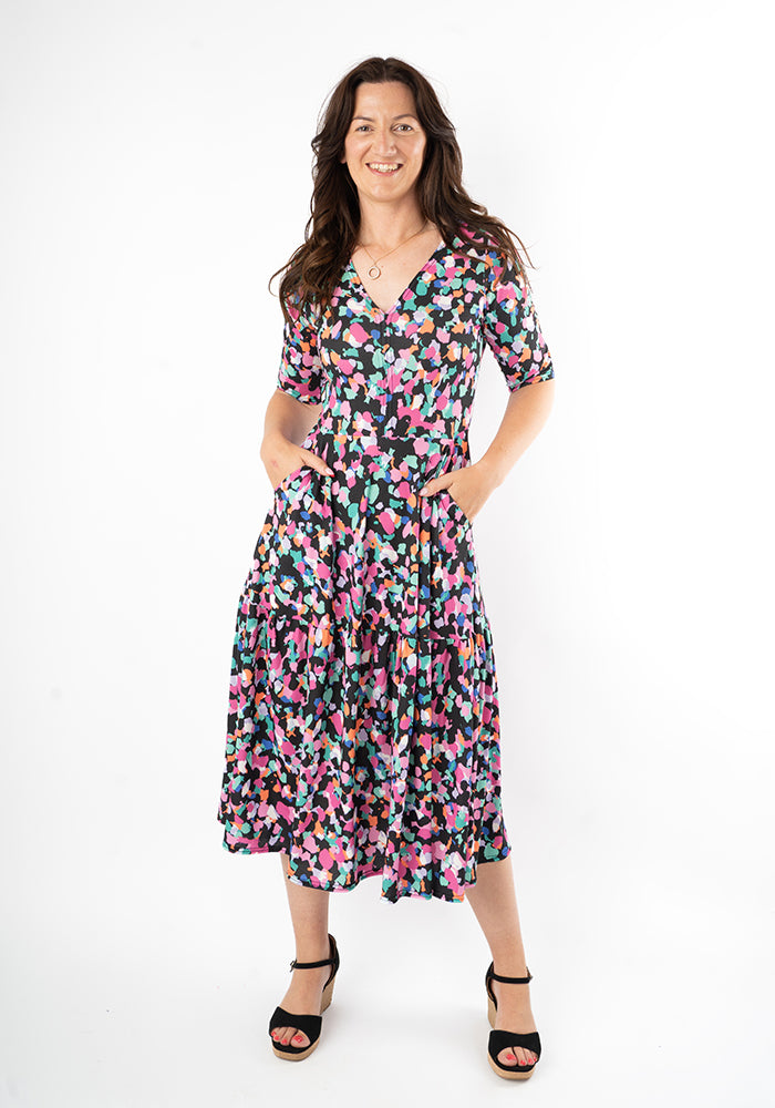 Woman wearing a animal print dress with both hands in pockets