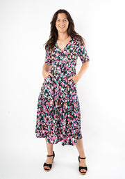 Woman wearing a animal print dress with both hands in pockets