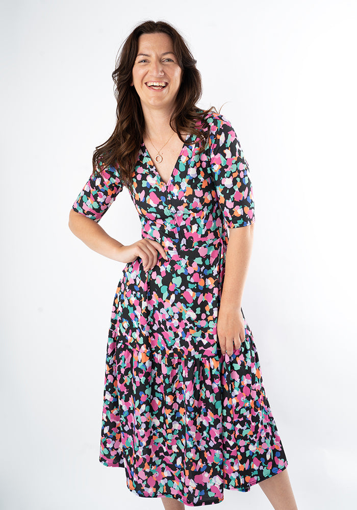 Woman wearing a colourful animal print dress on a white background