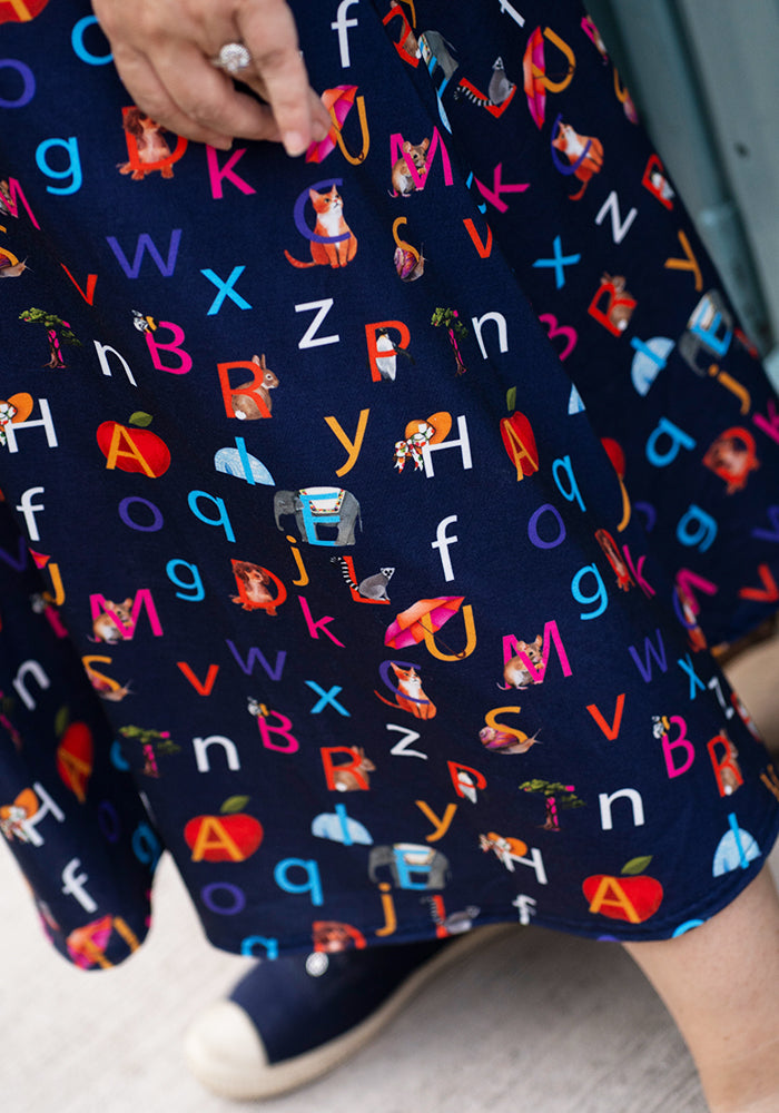 Navy blue midi dress with colourful alphabet and animal pattern phonics print