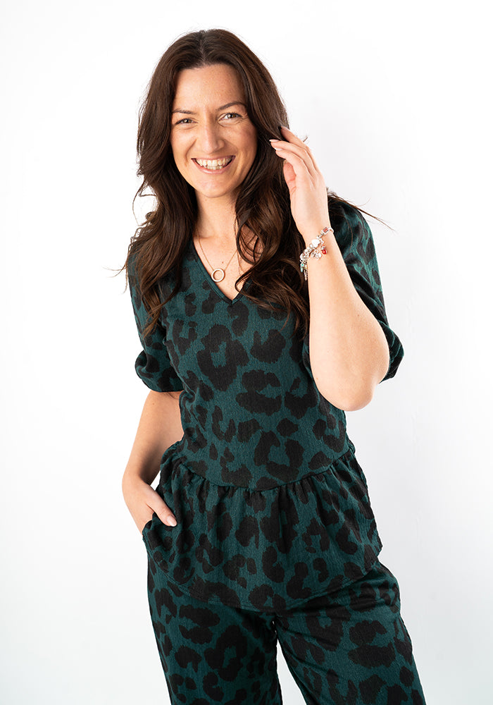 Front view of Deia Bottle Green Animal Print Peplum Top