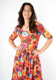 Woman wearing a colorful floral and cat print midi dress