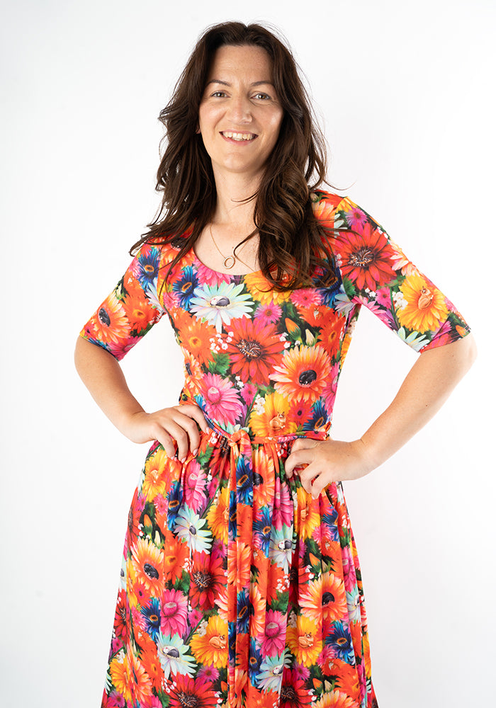 Woman wearing a colorful floral and cat print midi dress