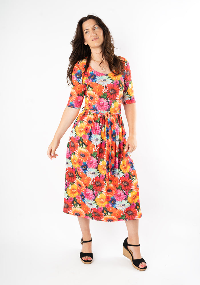 Woman wearing a colorful floral and cat print midi dress