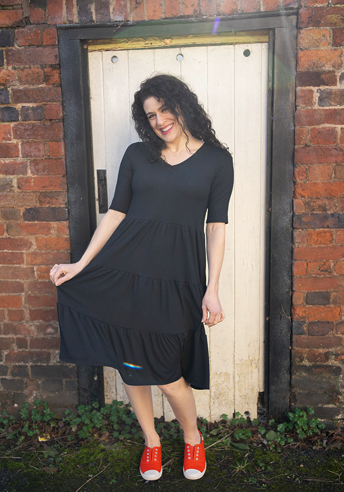 Front view of Reed Black Rib Brush Tiered Hem Dress