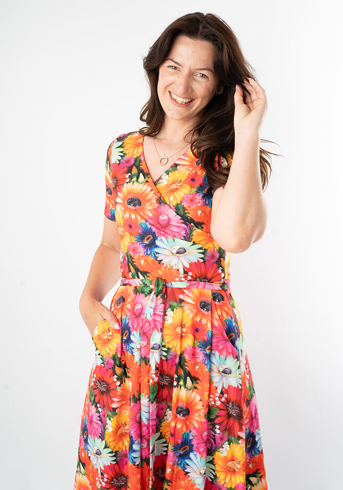 Woman wearing a colourful floral and cat dress
