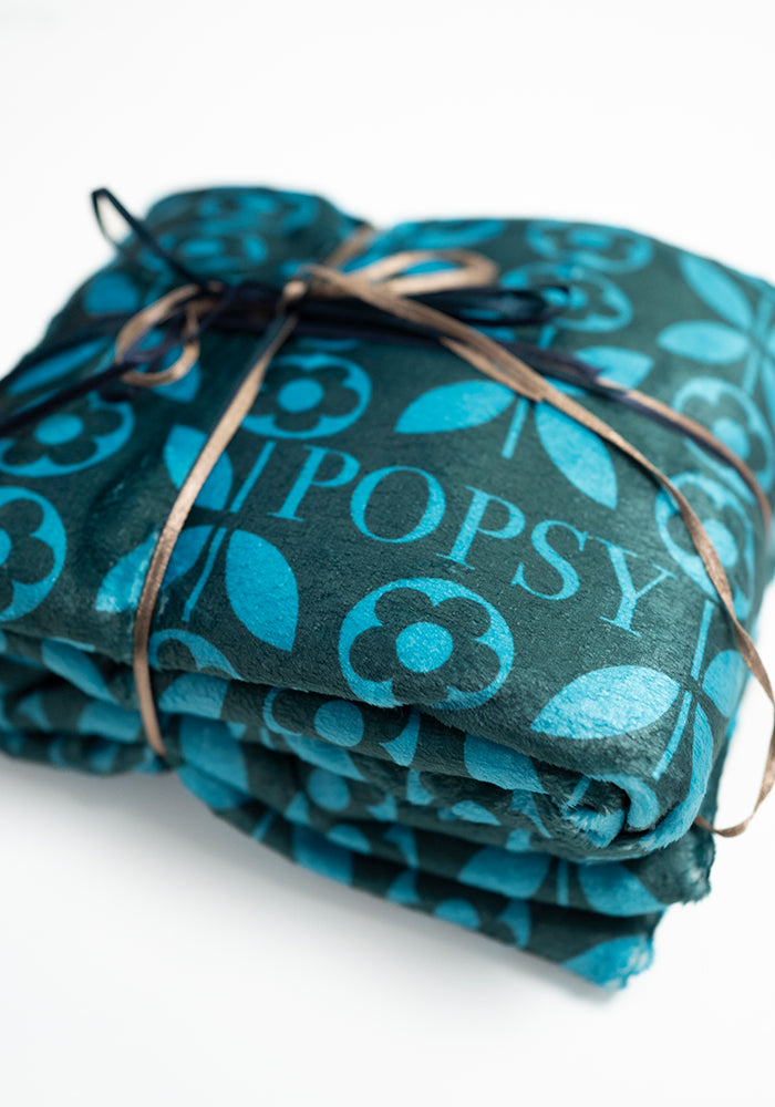 Front view of Teal Retro Flower Print Pop-under Plush Blanket