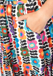 Colourful floral pattern on fabric with a hand in pocket
