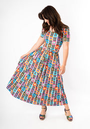 Woman wearing a colourful patterned dress on a white background
