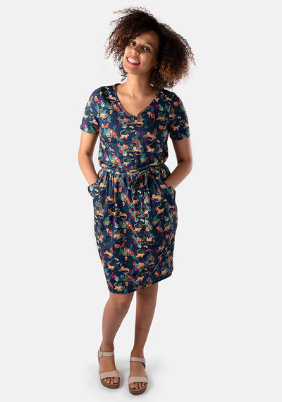 A full length front view of our Elia wild safari blouson dress. Style Stats: Jersey Fabric, Short Sleeve, V Neck, Blouson, Navy Ground and a Fabric Belt. 